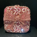 Detail of pink crystal clutch bag featuring a sparkling bow and rhinestone buckle - Pink