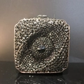 Vue détaillée d'une pochette carrée de luxe avec strass noirs et cristal central - Noir