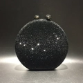 Detail of a round black crystal evening clutch bag featuring a sleek sphere metal clasp - Black