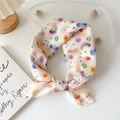 Floral cotton linen scarf with butterfly prints tied in a bow on a wooden stand - Rainbow Flower Ladybug