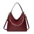 Deep red pebbled leather hobo handbag with wide strap and tassel detail on white background - Red
