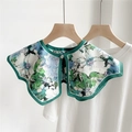Bloemen nep kraag in blauw en groen met metalen knoop op een wit t-shirt achtergrond - Witte Bloemen en Groene Bladeren