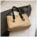 Detail der beigen Wildleder-Tragetasche mit schwarzen Knotengriffen und Holzperlen-Deko - Khaki