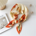 Pleated square scarf with orange floral prints styled as an elegant bow tie accessory - Plum Orange