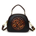 Black embossed crossbody bag with brown trim, vintage style handles and adjustable strap - Black