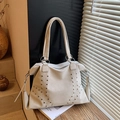 Elegante borsa tote beige con borchie argentate e zip su uno sfondo raffinato - Bianco Sporco