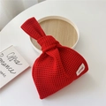 Detail einer roten Stricktasche mit Knotengriff und minimalistischem Hilldi-Markenetikett - Rot