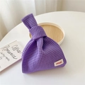 Detail of purple hollow knit tote bag featuring a minimalist brand label and knot handle - Purple