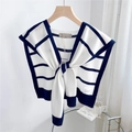 Close-up of striped knit shawl with brand tags hanging on a wooden hanger in a bright room - Beige with Navy Stripes