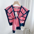 Detail of pink and navy striped knit shawl featuring ribbed edges and brand tag on a hanger - Pink with Navy Stripes