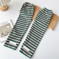 Close-up of pink and green striped knit arm sleeves with branded label on wooden surface - One Size / Green and Pink Stripes