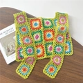 Detail der bunten Häkelweste mit Granny-Square-Blumenmuster auf grünem Strickstoff - 35*78cm / Buntes Gitter Gelb