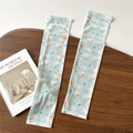 Detail of light blue sun protection ice sleeves with cloud and floral pattern on wood - One Size