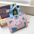 Dettaglio della borsa tote in maglia con motivo smiley blu e chiusura con bottone nero - Rosa