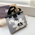 Detail of grey knitted tote bag with black flower pattern and secure snap button closure - 22*28cm / Grey Tri-Color Flower