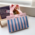 Dettaglio della borsa in maglia a righe rosa e blu con trama spessa e chiusura a bottone - Righe Verticali Rosa e Blu