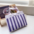 Dettaglio ravvicinato della borsa tote in maglia a righe con motivi viola e chiusura a bottone - Strisce verticali viola