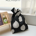 Detailed view of black and white knitted tote bag with geometric drop patterns and knot handle - Teardrop Polka Dot / Black Mango Pattern