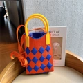 Close-up of orange and blue checkered knit mini bag with yellow handle on a chair - Orange & Blue Argyle