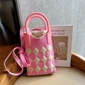 Macro shot of pink and cream checkered knit pattern and soft rubber handle on mini bag - Pink & Beige Argyle