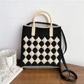 Detail of checkered knit crossbody bag with top handle and shoulder strap in black and white - Black & Cream Argyle