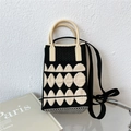 Dettaglio di una mini borsa in maglia con motivi geometrici e manici curvi beige - Nero / Bianco Jacquard