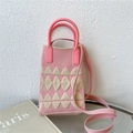 Close-up of pink and beige knitted phone bag with geometric pattern and round handles - Pink Rounded