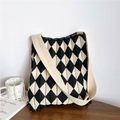 Close-up of black and white argyle knit tote bag texture with wide shoulder strap - Black and Beige Argyle (White Strap)