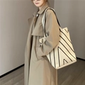 Makroaufnahme der cremefarbenen Stricktasche mit geometrischem schwarzen V-Muster - Diagonal-Köper-Stil / Beige