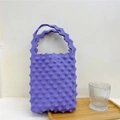 Close-up of purple popcorn textured knit handbag with wavy handle and elastic bubble fabric - Purple
