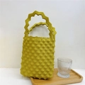 Detailed view of yellow knitted handbag with wavy texture and zigzag handle design - Khaki/Earth Yellow