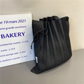 Close-up of black pleated knit tote bag with drawstring bow and accordion texture - Black