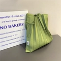 Detail of avocado green pleated knit tote bag with bow detail and brand tag - Light Green