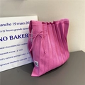 Detailed texture of pink pleated knit tote bag with decorative bow and October label - Deep Pink