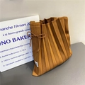 Detail of a brown pleated knit shoulder bag with an elegant side bow and accordion folds - Caramel color