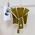 Dettaglio della sciarpa in maglia verde oliva con bordo bianco ed etichetta tessuta - Marrone Terroso