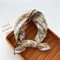 Dettaglio di un foulard floreale in cotone e lino con fiocco in un cesto intrecciato - 58cm / 19 Margherita Grigio