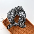 Detailed close-up of a knotted black and white floral cotton linen scarf on a rattan tray - Bamboo Floral Black (23)