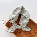 Detailed view of floral cotton neckerchief on a rustic woven basket with a card - Bamboo Floral Green (24)
