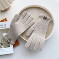 Close-up of oatmeal knitted gloves featuring thick vertical ribbing and brown leather tag - Coffee (Ruffle Cuff)