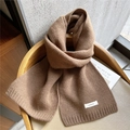 Brown 100% wool knitted scarf for women with ribbed edges on a minimal wooden chair - Brown