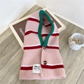 Dettaglio di sciarpa con cappuccio in maglia a righe con bordo verde e bottoni marroni - Rosa