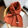 Solid bright orange 100% wool knitted scarf with ribbed edges on a wooden chair - Orange