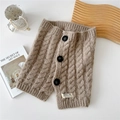 Detail of warm camel knit neck warmer with thick cable pattern and three black buttons - Coffee