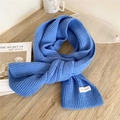 Solid Klein blue chunky knit scarf with white label on a minimalist wooden background - 21x162cm / Royal Blue