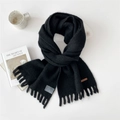Black knitted scarf with tassels and decorative leather tag on white artistic background - Black (4D)