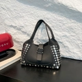 Borsa a secchiello in pelle martellata nera con rivetti argentati su tavolo di legno - Nero