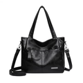 Black glossy leather tote bag with dual straps and metallic logo plate on white background - Black