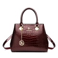 Bolso burdeos brillante con patrón de cocodrilo, logotipo de canguro dorado y asa superior - Burdeos