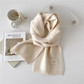 Chic cream white knitted winter scarf featuring a woven label and soft ribbed texture - Cream